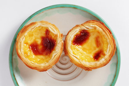 Pastel de Nata on a plate on white background, top view