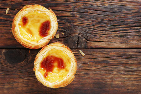 Portuguese Egg Tart "Pastel de nata" on a wooden background, top view with copy spaceの写真素材