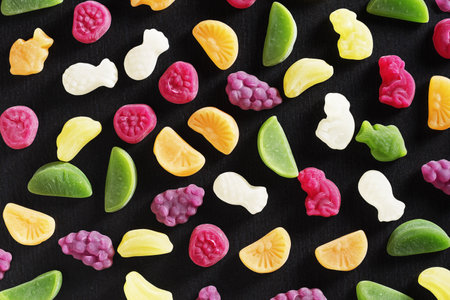 Various gummy candies on black stone background, top viewの写真素材