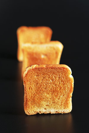 Slices of small toasted bread on black backgroundの写真素材