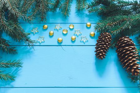 Christmas tree branch with cone on a wooden background, marbles, starsの写真素材