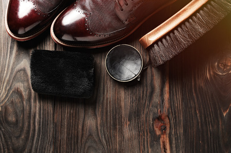 leather shoes on table with polishing equipment. Fashion shoes handmade. Wax. Wooden backgroundの写真素材