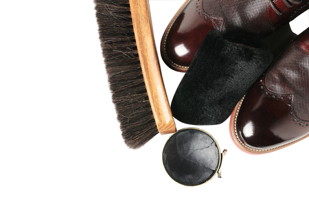 Isolated leather shoes on table with polishing equipment. Fashion shoes handmade. Wax. Wooden backgroundの写真素材