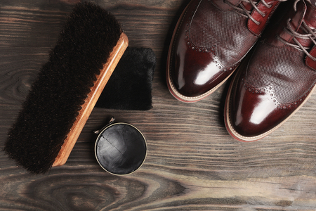leather shoes on table with polishing equipment. Fashion shoes handmade. Wax. Wooden backgroundの写真素材