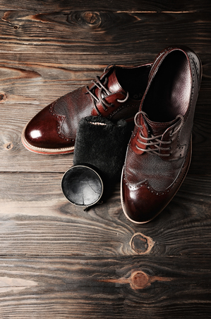 leather shoes on table with polishing equipment. Fashion shoes handmade. Wax. Wooden backgroundの写真素材