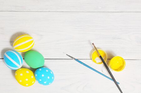 Close up of colorful Easter eggs on white wodden table. brush and paintの写真素材
