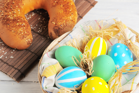 Easter eggs in the nest and bread on rustic white background. Traditional easter cakeの写真素材