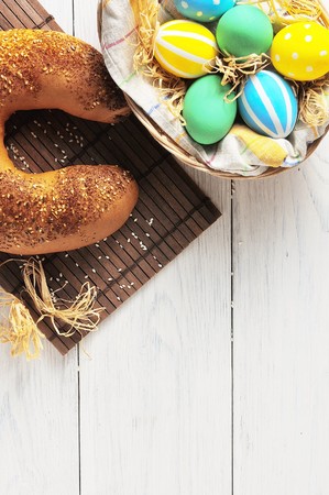Easter eggs in the nest and bread on rustic white background. Traditional easter cakeの写真素材