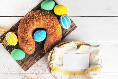 Easter eggs in the nest and bread on rustic white background. Traditional easter cakeの写真素材