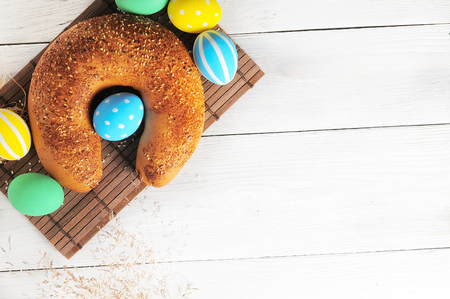 Easter eggs in the nest and bread on rustic white background. Traditional easter cakeの写真素材