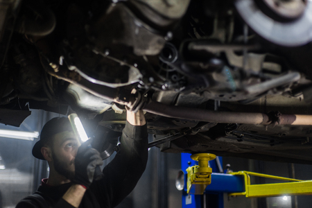 Young caucasian man repairing car with professional toolsの写真素材