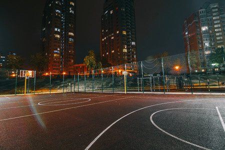Illuminated basketball playground on red background.の写真素材