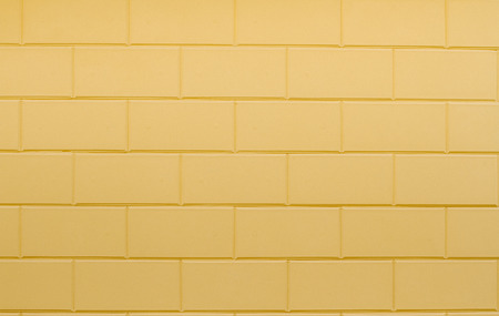 Tiled old painted yellow brick wall background in Kyiv, Ukraineの写真素材