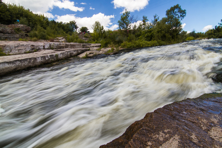A small rapid at the middle of Hirsky Tikych river with swallow water in Buky, Cherkasy region, Ukraineの写真素材