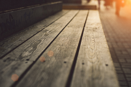 Modern wooden bench with deep texture close up at sunset warm lightの写真素材