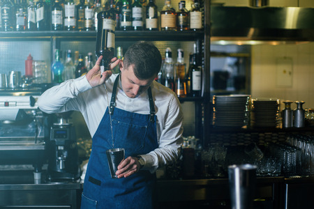 Bartender professionally working with om making drinks and cocktailsの写真素材