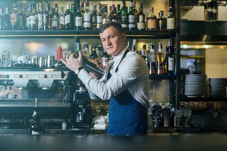 Bartender professionally working with shaker and making good drinksの写真素材
