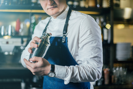 Bartender professionally working with shaker and making good drinksの写真素材