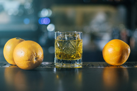 Old Fashioned whiskey coctail, server with oranges close upの写真素材