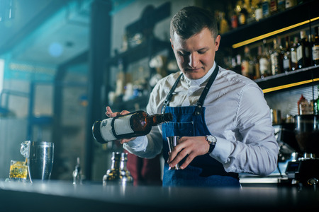 Bartender professionally working with om making drinks and cocktailsの写真素材