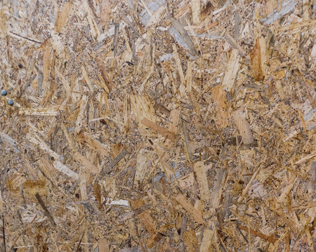 OSB boards are made of brown wood chips sanded into a wooden background. Top view of OSB wood veneer backgroundの写真素材