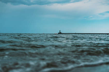 Sea waves at Odessa beach with lighthouse on backgroundの写真素材