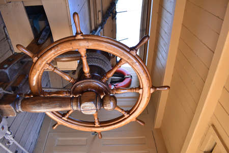 Steering wheel or helm from wood on the deck of old historical boat wheaer