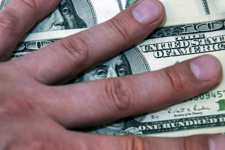 Male greed closed the dollars with their handsの写真素材