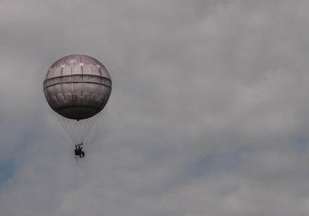 A pink hot air balloon flies in the cloudy sky. The photo was shot in summer Prague, Czech Republic and could be good for a background or a greeting card.の写真素材