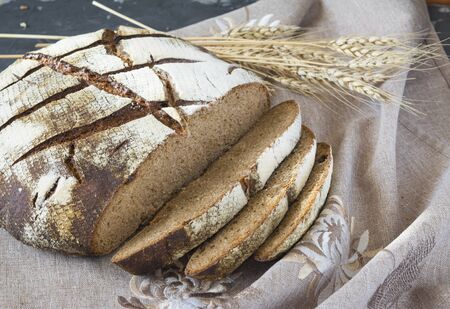 Sliced ??rye bread on the grey napkin with wheat spike.
