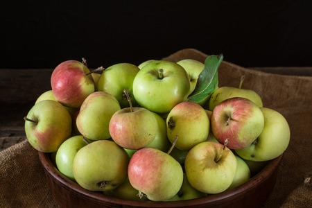 Ripe red and green apples on wooden background. Apples in bowl. Garden fruits. Autumn fruits. Autumn harvest.の写真素材