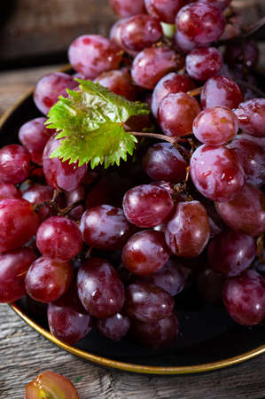 Pink grape on wooden table on wooden background. Vine grape. Still life of food