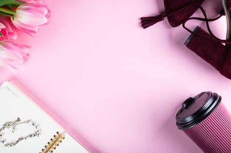 Female home office desk. Workspace with notebook, pink tulip flowers and accessories. Flat lay, top...