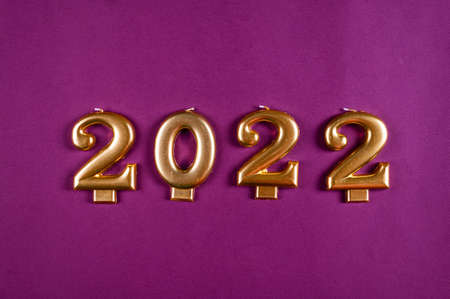New Year 2022 golden candles on purple background. 2022 year. New year flatly. New year background