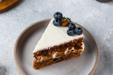 piece of carrot cake with walnuts and blueberry on light background. Local food. Traditional american cake. Cake for thanksgiving day. Autumn cakeの写真素材