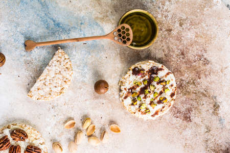 Rice cake with honey and nuts. Healthy breakfast. Macadamia nuts with honey. Vegetarian breakfast. Sweet breakfast top view. Rice dessert. healthy christmas dessertの写真素材