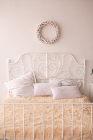 a bed with white pillows and metal railings in the interiorの写真素材