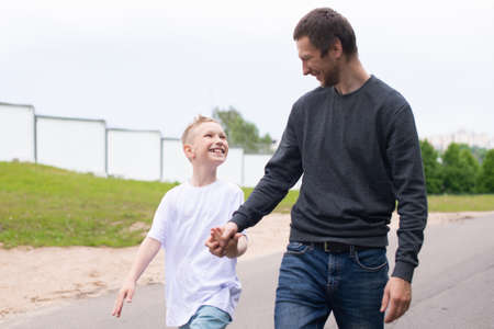 standing next to the child, teaching the son, showing the direction, entertaining the child, studying, dad, son, child, father, upbringing, development, interest, watching, playing, family vacation, nature walk, spring, reaching for flowers, blooming treeの写真素材