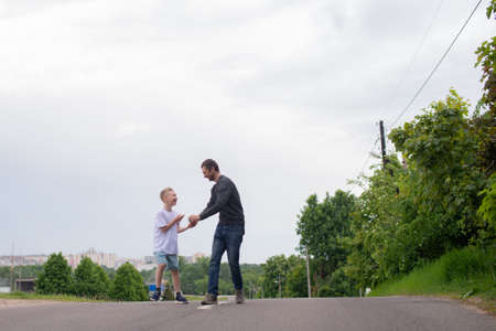 standing next to the child, teaching the son, showing the direction, entertaining the child, studying, dad, son, child, father, upbringing, development, interest, watching, playing, family vacation, nature walk, spring, reaching for flowers, blooming treeの写真素材