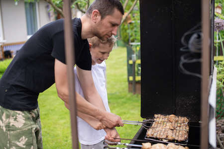 roast meat, food on fire, coals, fire, marinade, nature, fun company, family day, white t-shirt, cooking, cooking, cooking, fatherhoodの写真素材