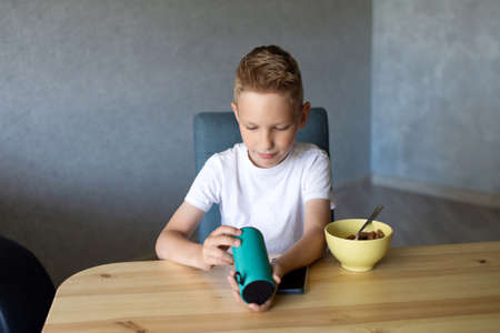 baby teeth, loss of baby teeth, Little boy, teenager, listening to music, gadgets, headphones, loud music, dancing, singing, listening to music, sound around, sitting on a chair, laughingの写真素材
