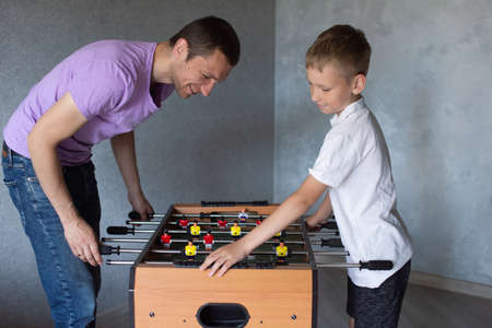 white t-shirt, foosball, dad and son, little boy, play football, twist levers, home games, white...