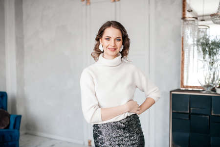 beautiful hairstyle, interior, white hoodie , place for advertising, cooperation, business, looking into the camera, young girl, style, fashion, expectation, horizontal, place for text, laughter, girl is happyの写真素材