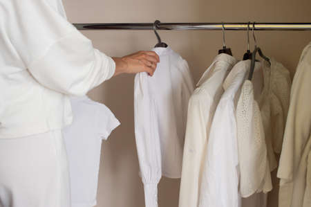 Remove a white shirt from a hanger in the closet