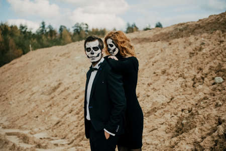 A man and a woman in skeleton makeup celebrate Halloween