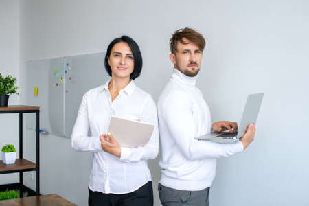 Work colleagues, a man and a woman in the officeの写真素材