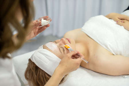 A white face mask is applied with a brushの写真素材