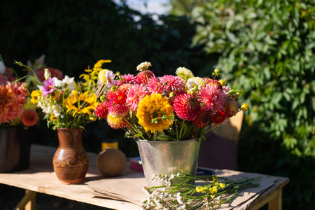 Bouquets of autumn flowers are on a wooden table outside in a bucketの写真素材