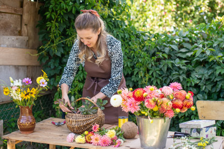 A florist girl collects a bouquet of autumn flowers in a basket on the streetの写真素材