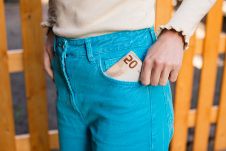 Put money in the front pocket of blue pantsの写真素材